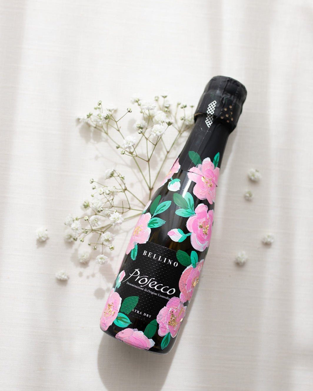 Hand painted pink roses with gold leaf accents in the centres. Painted onto mini bottles of Prosecco. a perfect bridesmaids proposal gift. Fancy Folk Design
