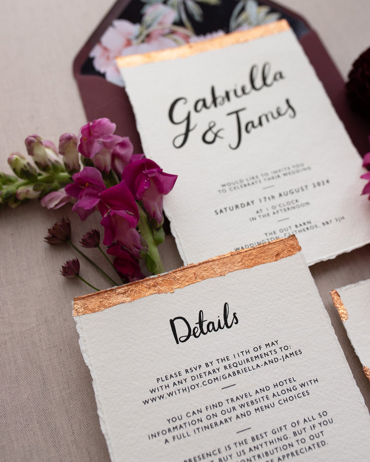 Modern Calligraphy Wedding Invitation, Details Card with rich burgundy coloured envelopes. Our wedding stationery features a beautiful hand lettered calligraphy names design printed on textured handmade Indian paper with hand torn edges for a soft romantic feel. Each piece is lovingly hand finished with copper leaf for a luxury feel. Styled with burgundy and coral florals, perfect for autumn and winter weddings. Fancy Folk