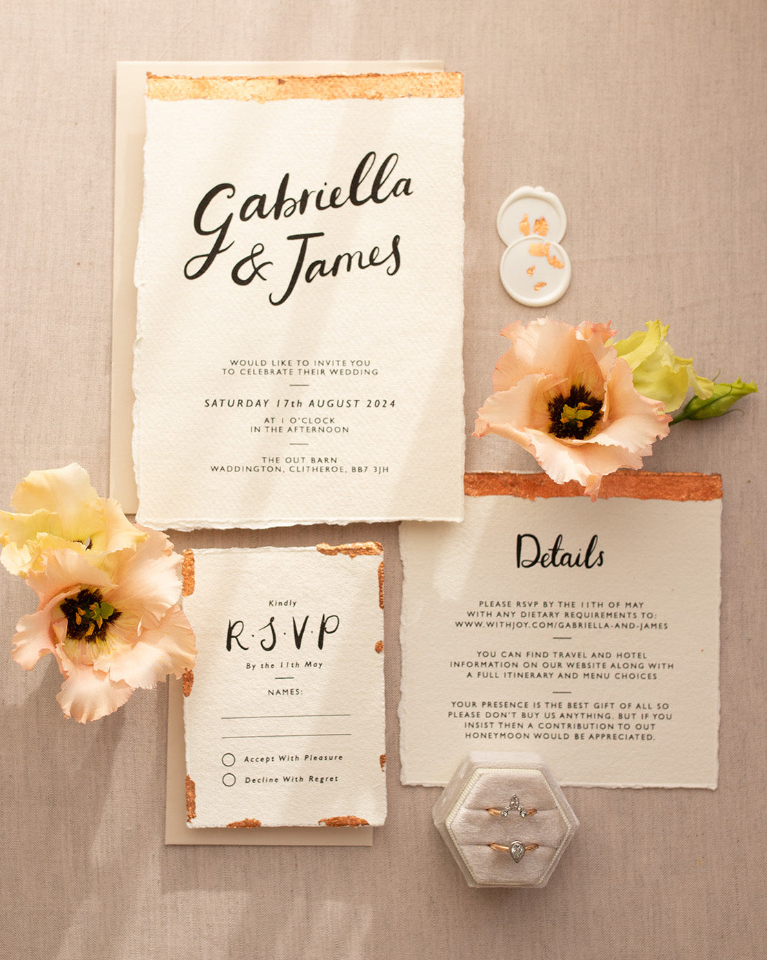 Modern Calligraphy Wedding Invitation, Details Card and RSVP with neutral almond coloured envelopes. Our wedding stationery features a beautiful hand lettered calligraphy names design printed on textured handmade Indian paper with hand torn edges for a soft romantic feel. Each piece is lovingly hand finished with copper leaf for a luxury feel. Styled with white and copper leaf wax seals and peachy florals. Fancy Folk