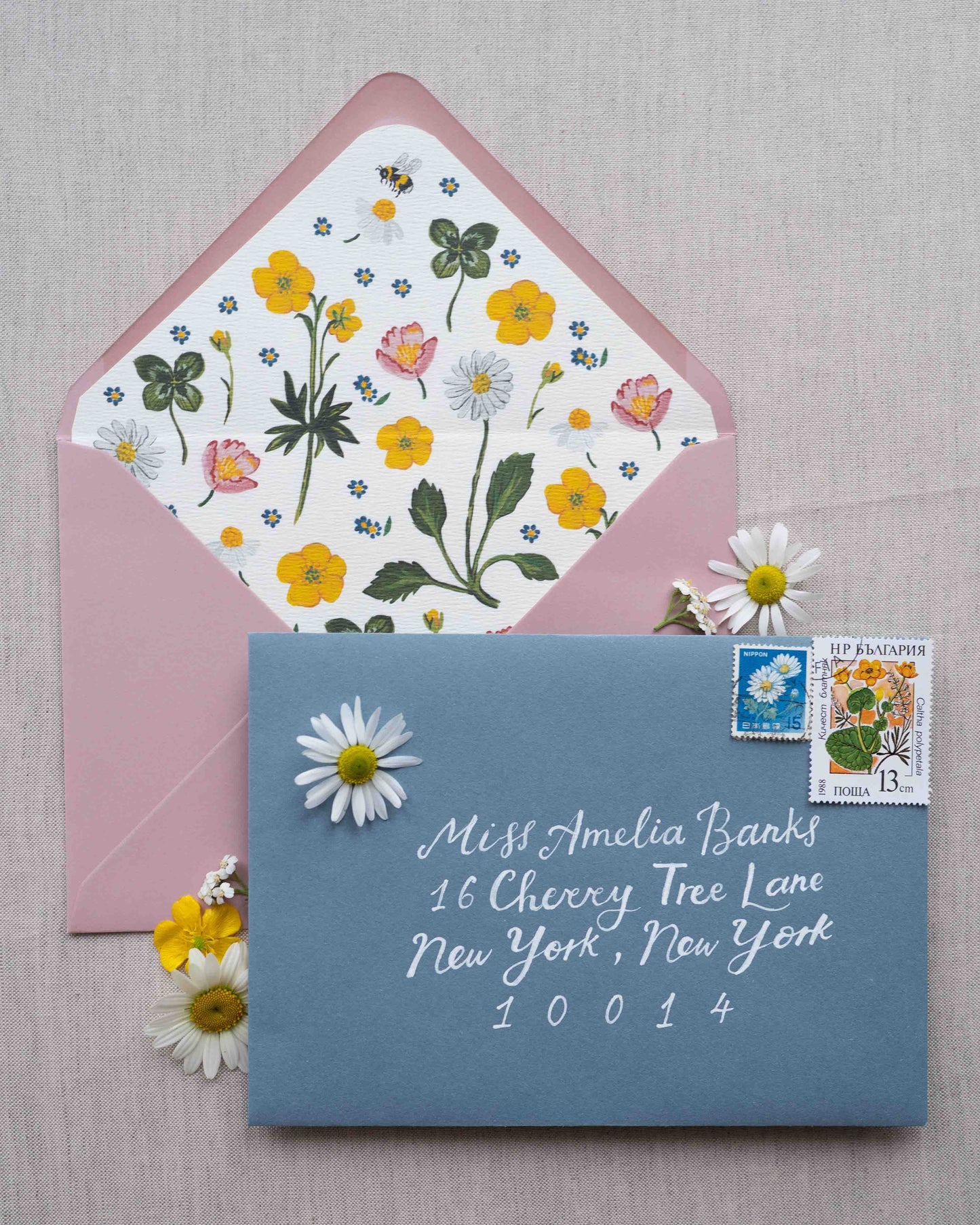 Dusty Blue envelope with floral design envelope liner. Calligraphy name and address in white ink. Styled with vintage floral stamps.