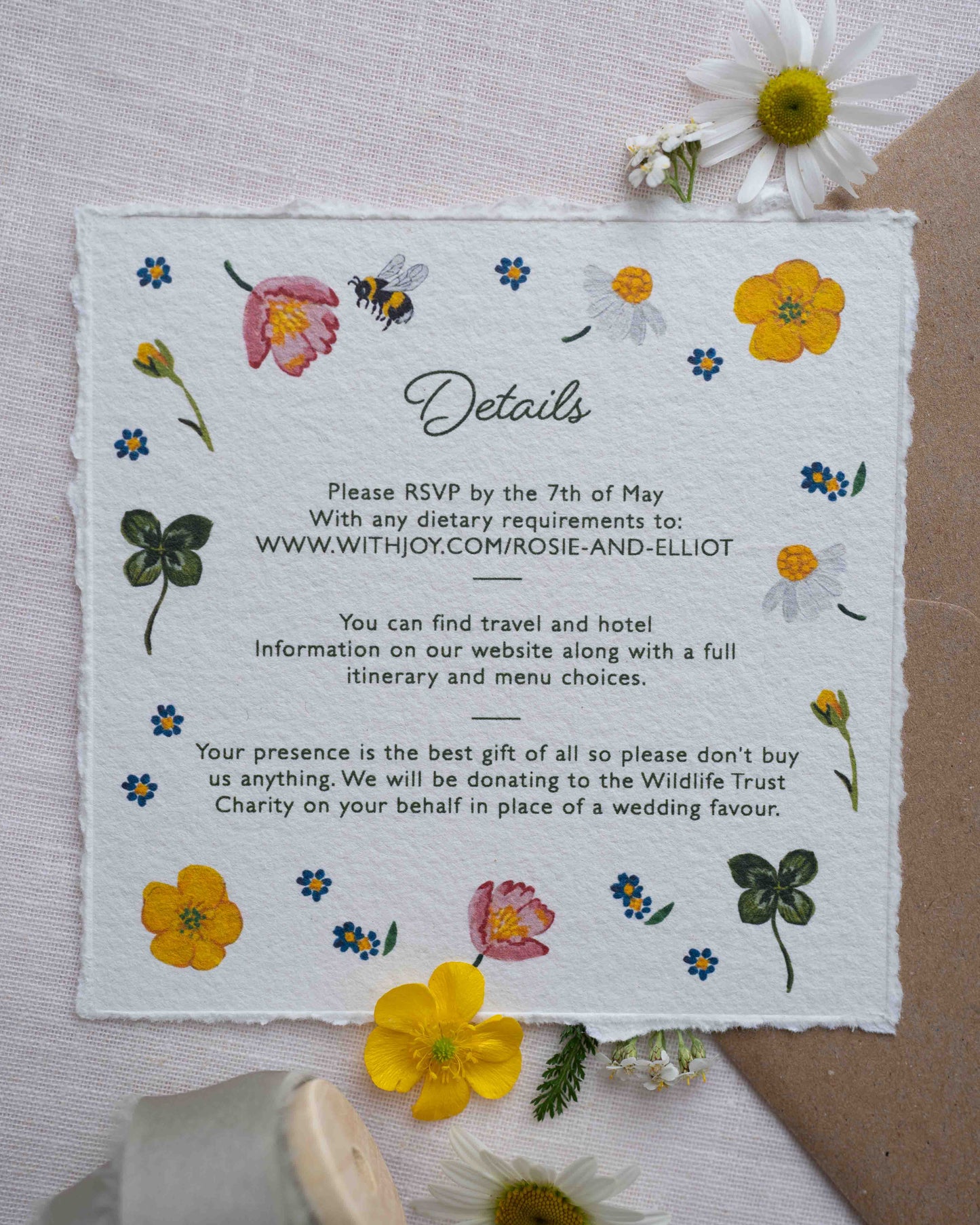 Watercolour hand painted florals of meadow flowers and a little bee make scattered around the edges of your details card. Printed on handmade Indian cotton paper. Fancy Folk Design