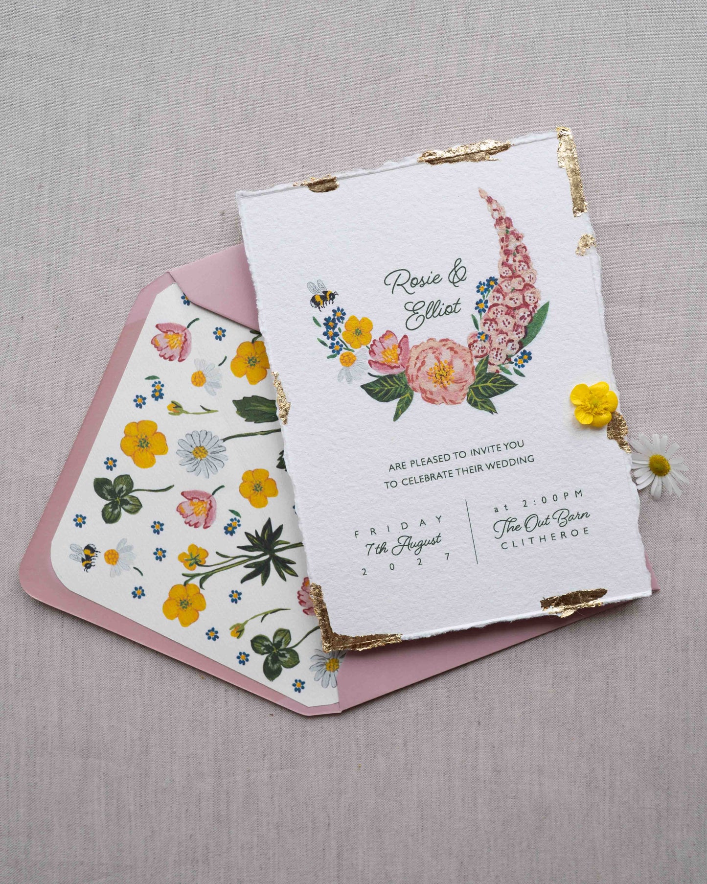 Watercolour hand painted florals of meadow flowers and a little bee make up a posy. Couples names are nestled in the floral. Printed on handmade Indian cotton paper with gold leaf accent. Styled with dusty pink envelopes and floral envelope liners. Fancy Folk Design