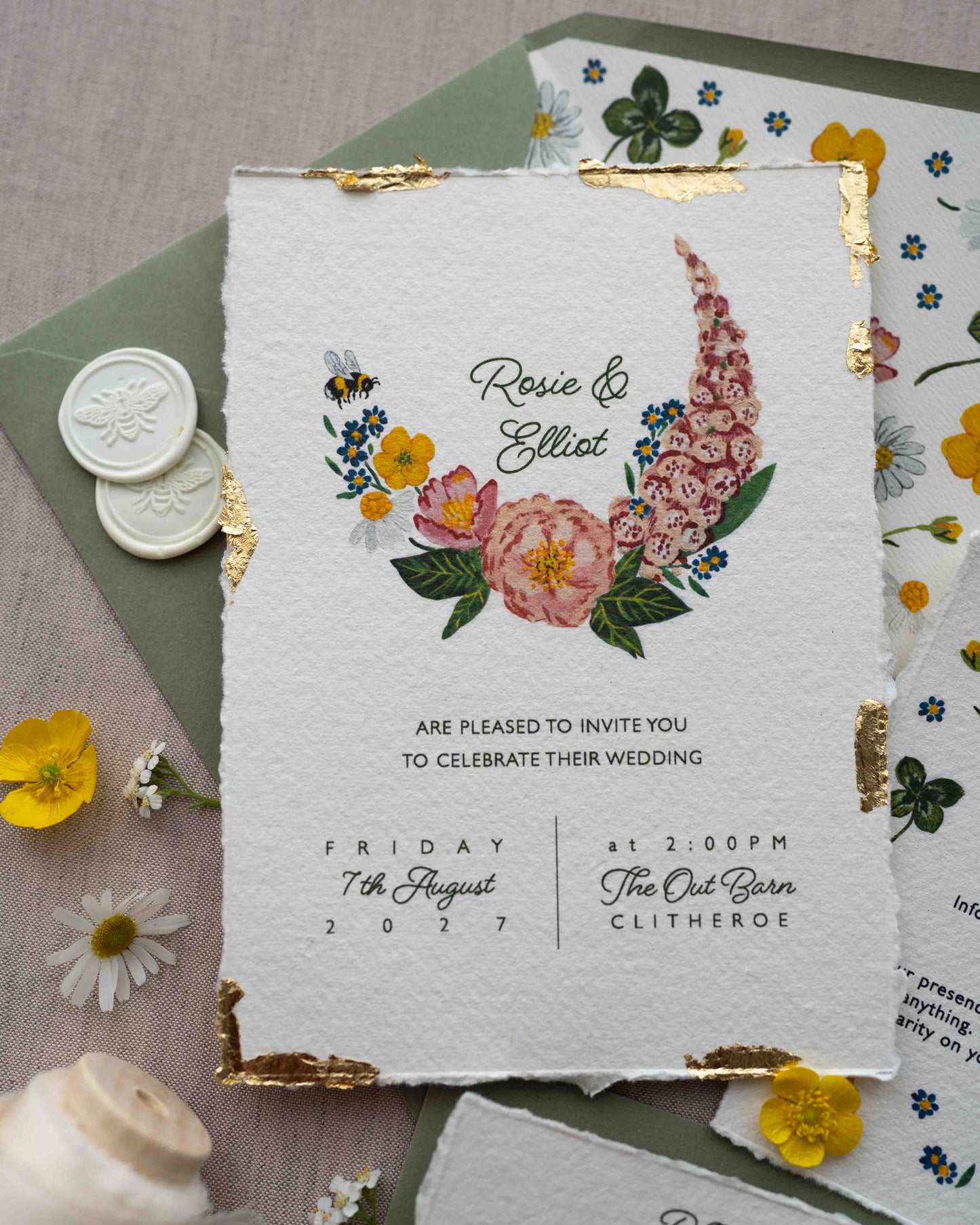 Watercolour hand painted florals of meadow flowers and a little bee make up a posy. Couples names are nestled in the floral. Printed on handmade Indian cotton paper with gold leaf accent. Styled with white bee wax seals, floral envelope liners and silk ribbon. Sage green envelopes and fresh flowers.