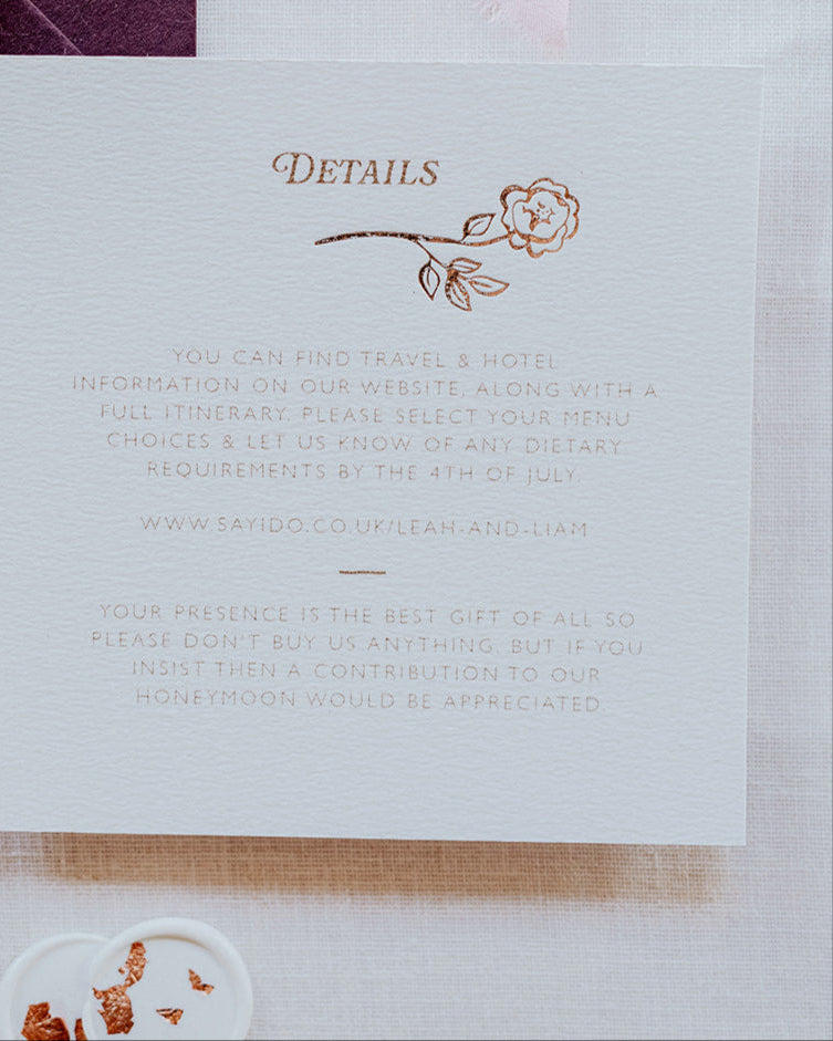 Close up of wedding details card featuring a foiled rose steam deign below the word 'Details'. Foiled onto  thick textured card with couples  information printed in a soft brown colour. Paired with smaller RSVP card, with a small foiled rose gold bow design and dusty pink envelope. Designed by Fancy Folk Wedding Stationery