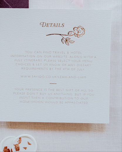 Close up of wedding details card featuring a foiled rose steam deign below the word 'Details'. Foiled onto  thick textured card with couples  information printed in a soft brown colour. Paired with smaller RSVP card, with a small foiled rose gold bow design and dusty pink envelope. Designed by Fancy Folk Wedding Stationery