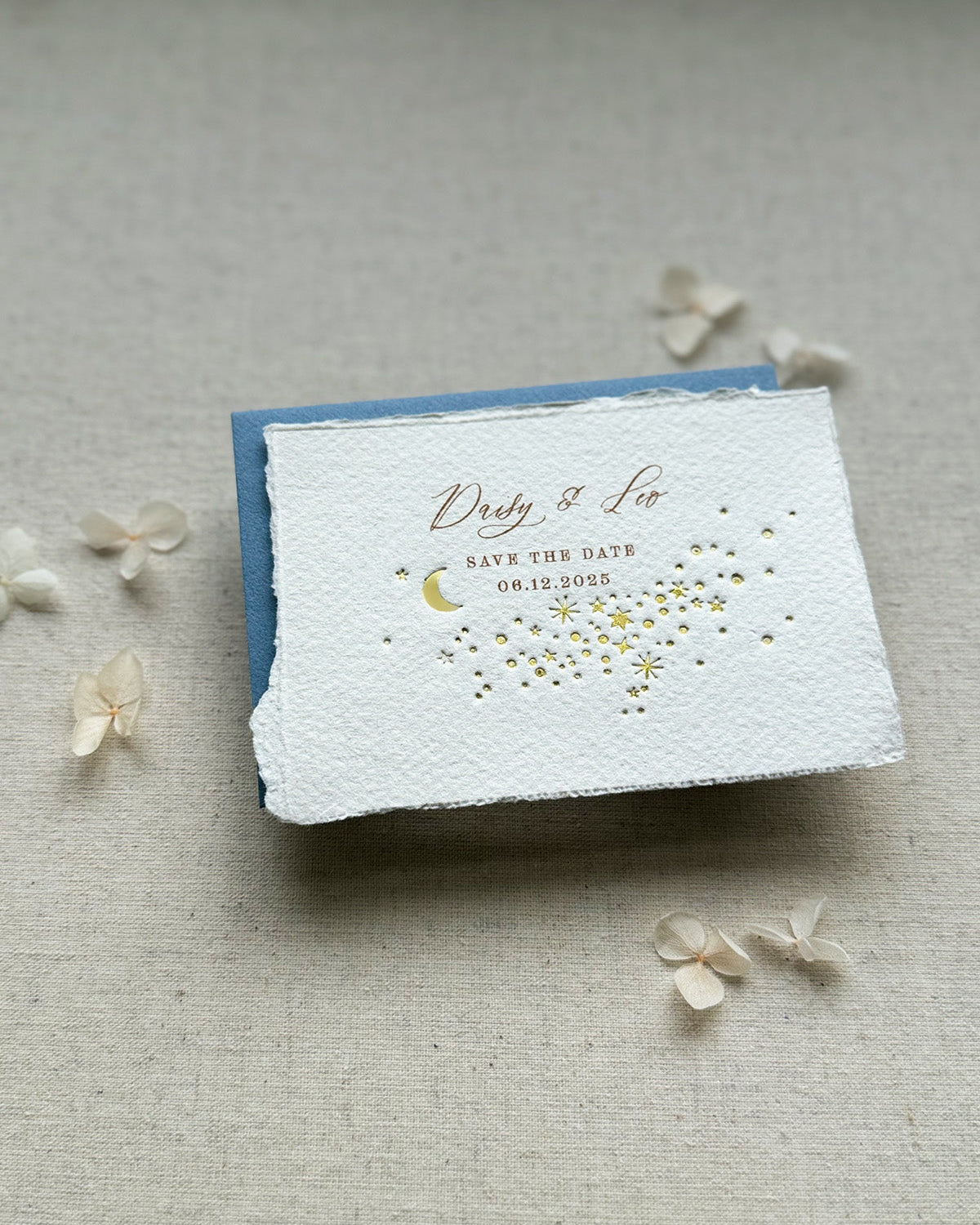 Celestial wedding save the date. Gold foil moon and stars design is embossed onto handmade paper with torn edges. Dusky Blue envelopes. Fancy Folk