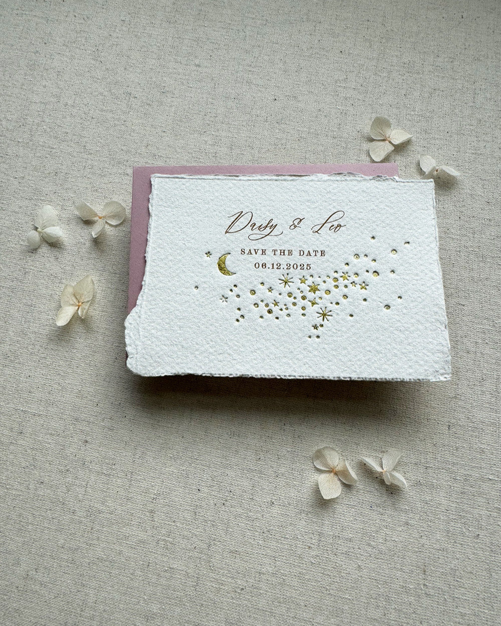 Celestial wedding save the date. Gold foil moon and stars design is embossed onto handmade paper with torn edges. Dusky Pink envelopes. Fancy Folk