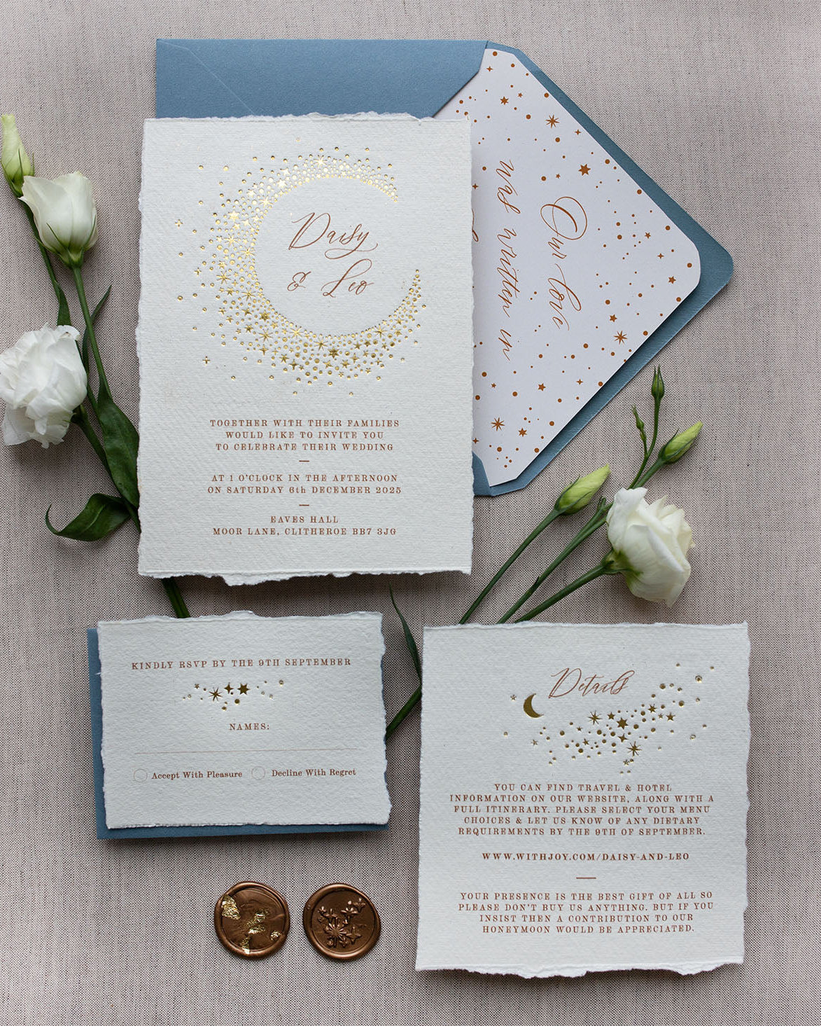 Celestial themed wedding stationery suite laid out in a flat lay format. A truly magical crescent moon design made up of lots of little stars is hot foiled in gold on to the main invitation. Smaller cluster of gold stars feature on the details card and RSVP. The invitations are foiled and printed onto tactile handmade paper with a torn romantic edge. Styled with gold wax seals, dusty blue envelopes with a luxury envelope liner which reads "Our love was written in the stars". FancyFolk Design