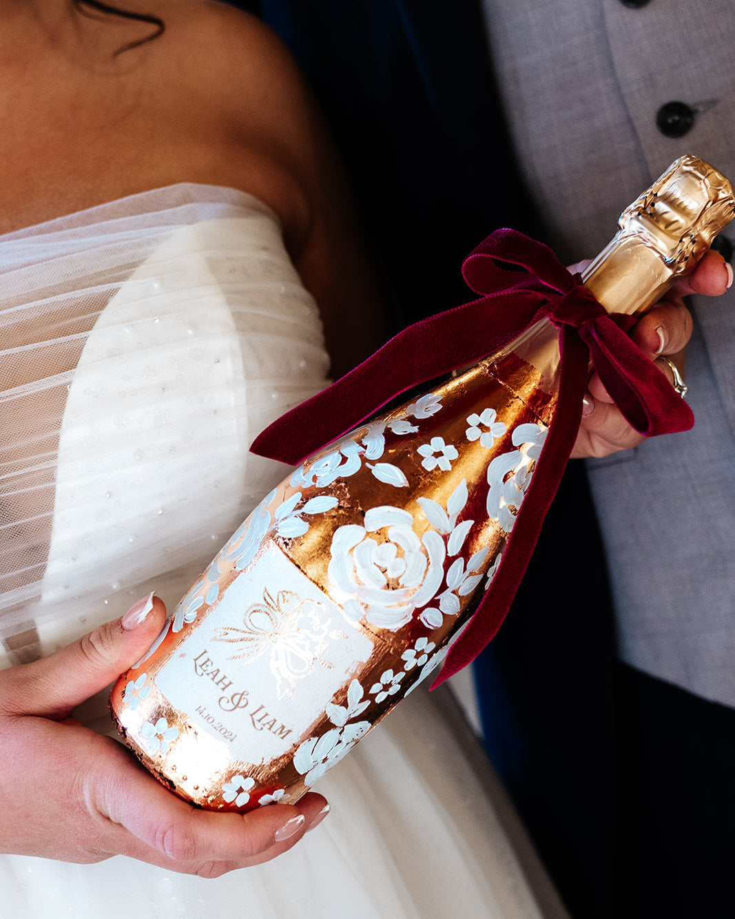with white painted roses all around the bottle. Personalise label with couples names and wedding date. Perfect for a Champagne Tower moment. By Fancy Folk Design