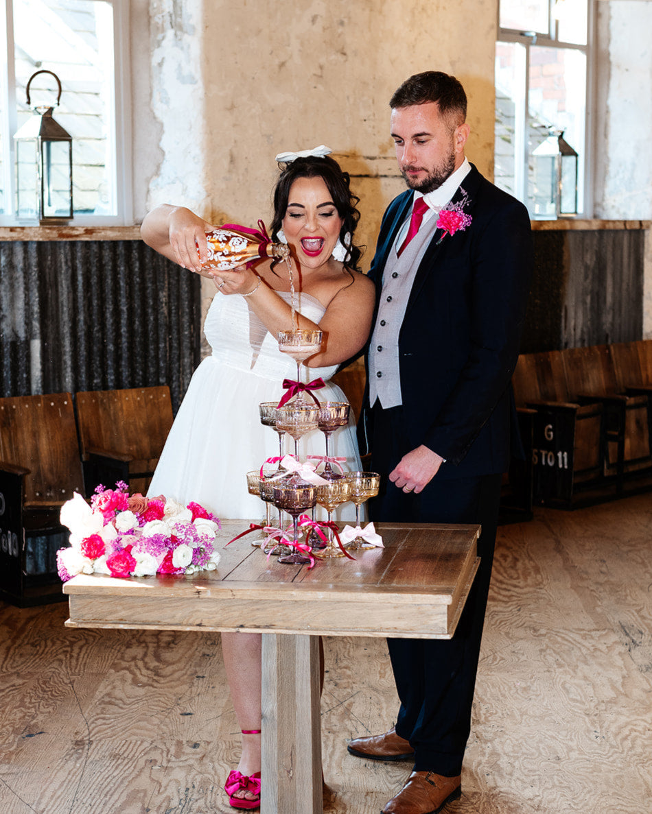 with white painted roses all around the bottle. Personalise label with couples names and wedding date. Perfect for a Champagne Tower moment.Poured y the bride. By Fancy Folk Design