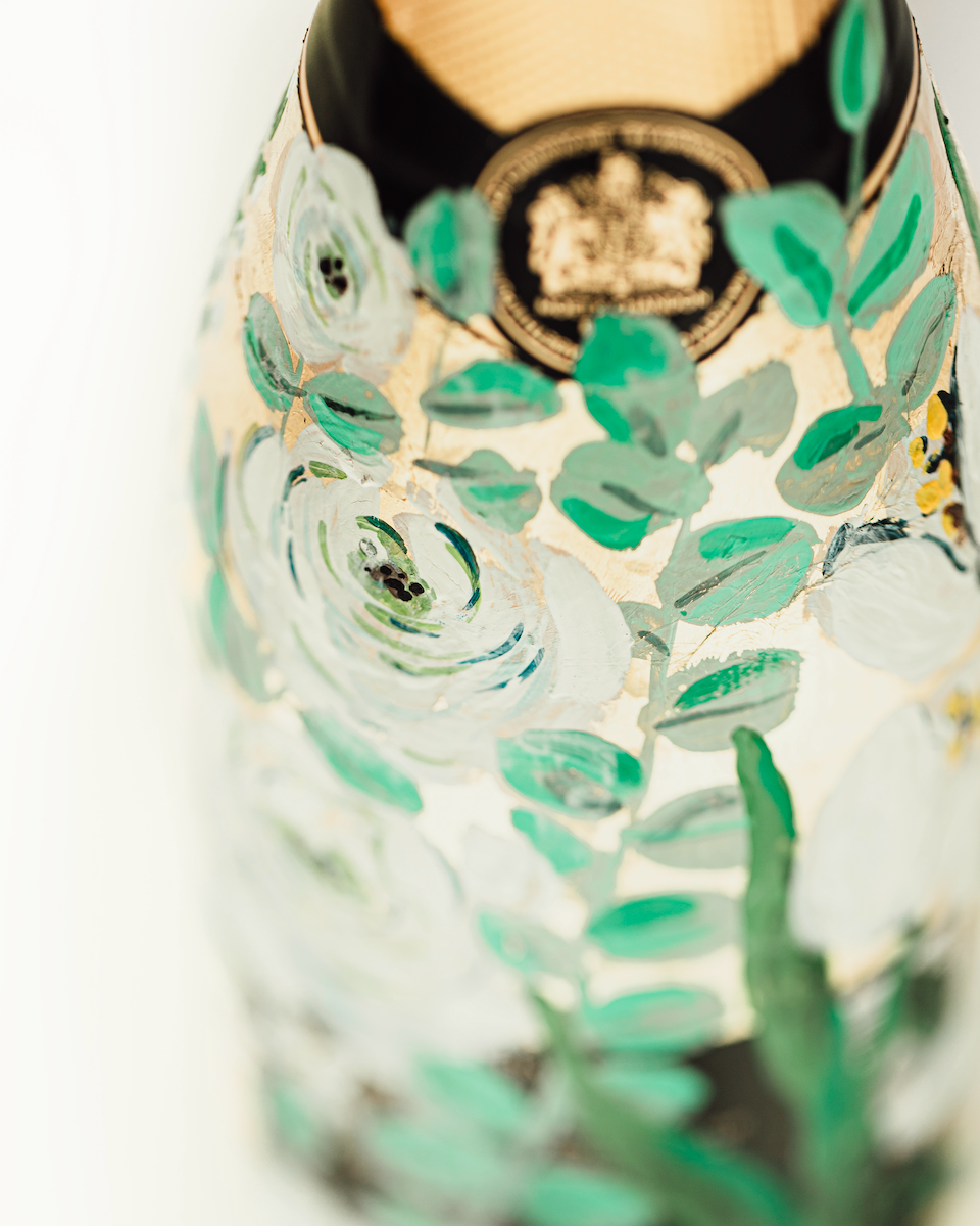 Close up of hand painted florals on a gold leaf base. Painted on a bottle of Champagne. Fancy Folk