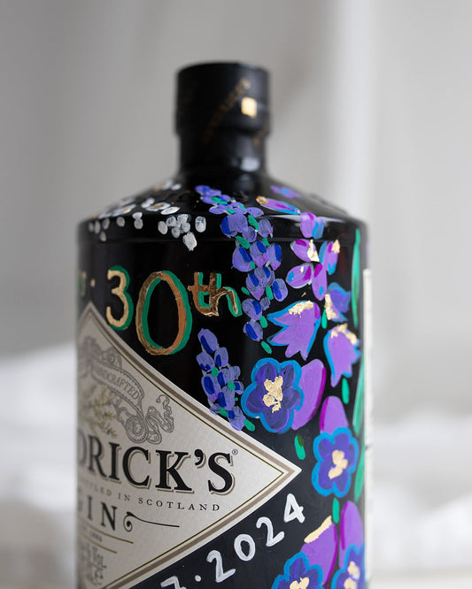 Hand painted occasion bottle. Blue and Purple Wildflowers which are embellished with gold leaf. Personalised initials and dates.