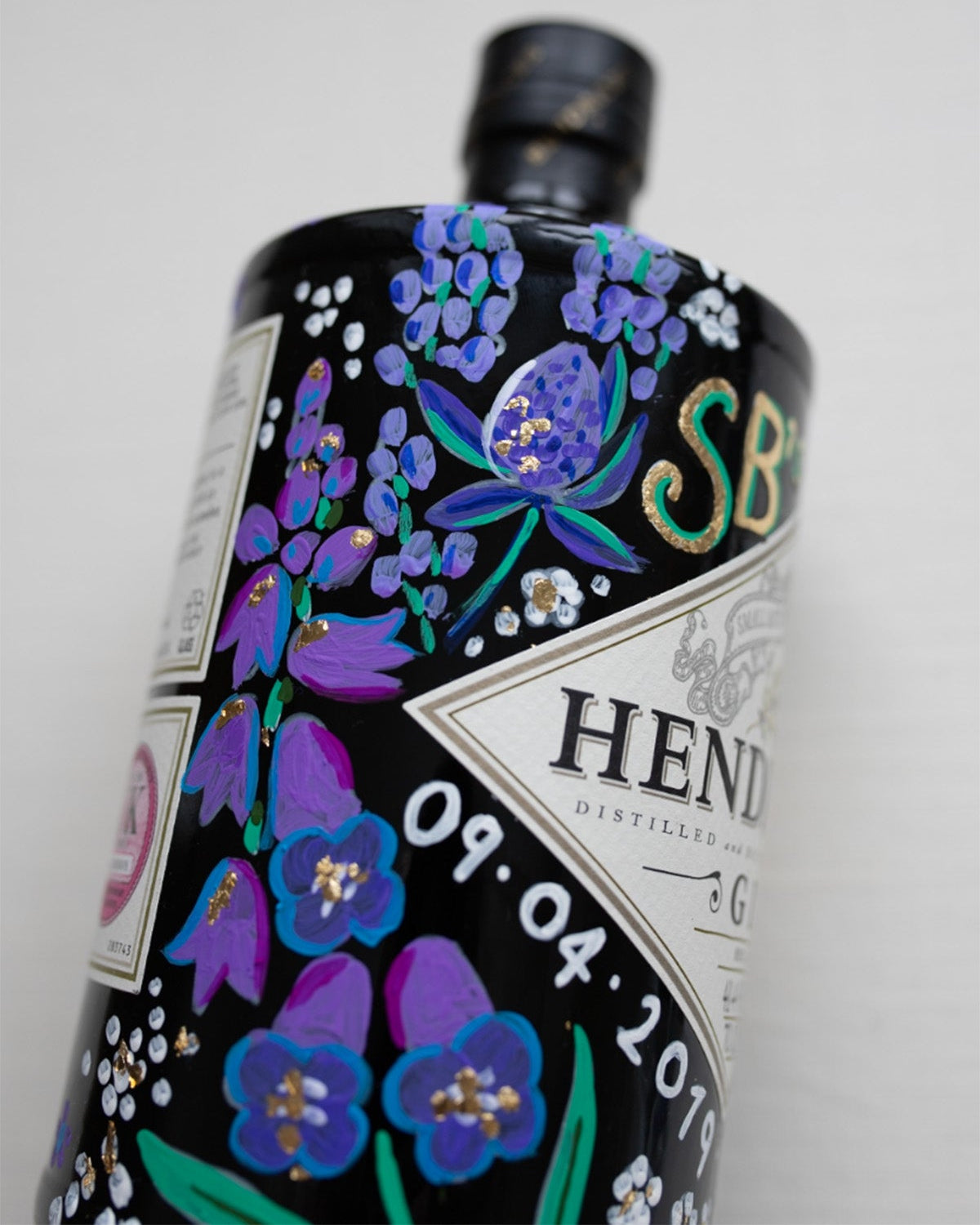 Purple and blue wild flower design, handprinted onto a celebration bottle. With memorable initials and dates to make the perfect personalised gift. Gold leaf accents ad a touch of sophistication and luxury. Fancy Folk