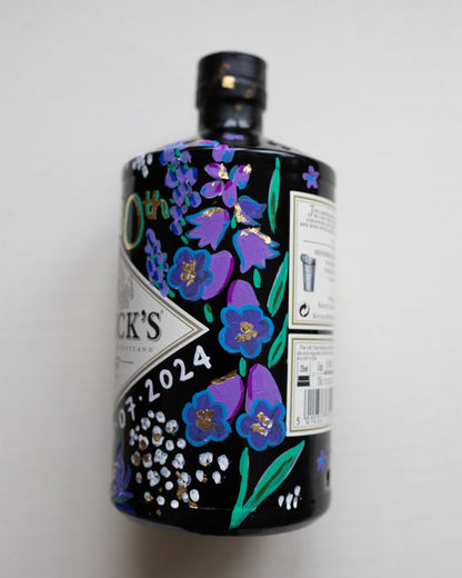 Hand painted occasion bottle. Blue and Purple Wildflowers which are embellished with gold leaf. Personalised initials and dates.