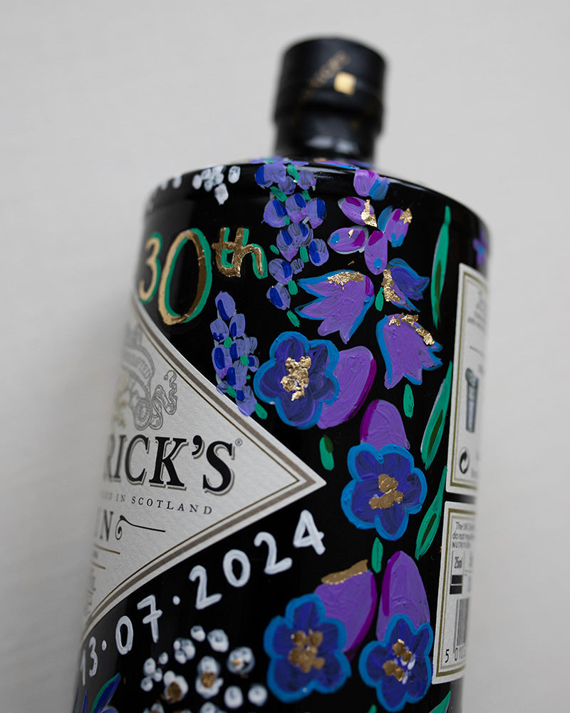Hand painted occasion bottle. Blue and Purple Wildflowers which are embellished with gold leaf. Personalised initials and dates.