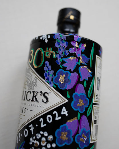 Hand painted occasion bottle. Blue and Purple Wildflowers which are embellished with gold leaf. Personalised initials and dates.
