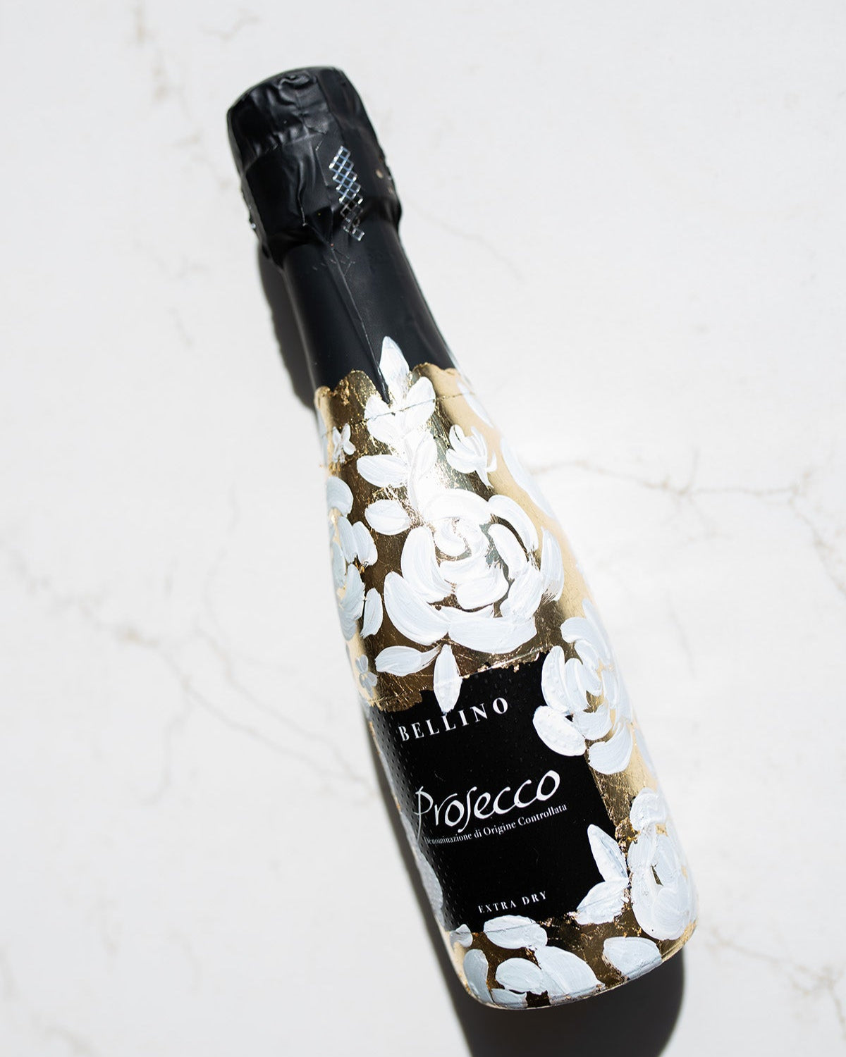 Mini bottles of Prosecco hand painted with a white roses design on a metallic gold leaf base. The perfect luxury bridesmaid proposal gift. Paired with a pink roses panted design available in a separate listing. Fancy Folk Design