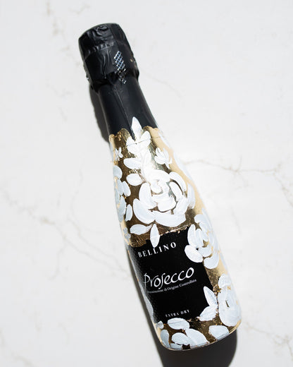 Mini bottles of Prosecco hand painted with a white roses design on a metallic gold leaf base. The perfect luxury bridesmaid proposal gift. Paired with a pink roses panted design available in a separate listing. Fancy Folk Design