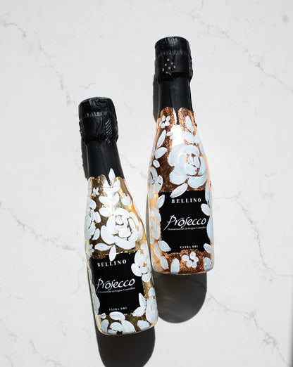 Mini bottles of Prosecco hand painted with a white roses design on a metallic gold and copper leaf base. The perfect luxury bridesmaid proposal gift. Paired with a pink roses panted design available in a separate listing. Fancy Folk Design