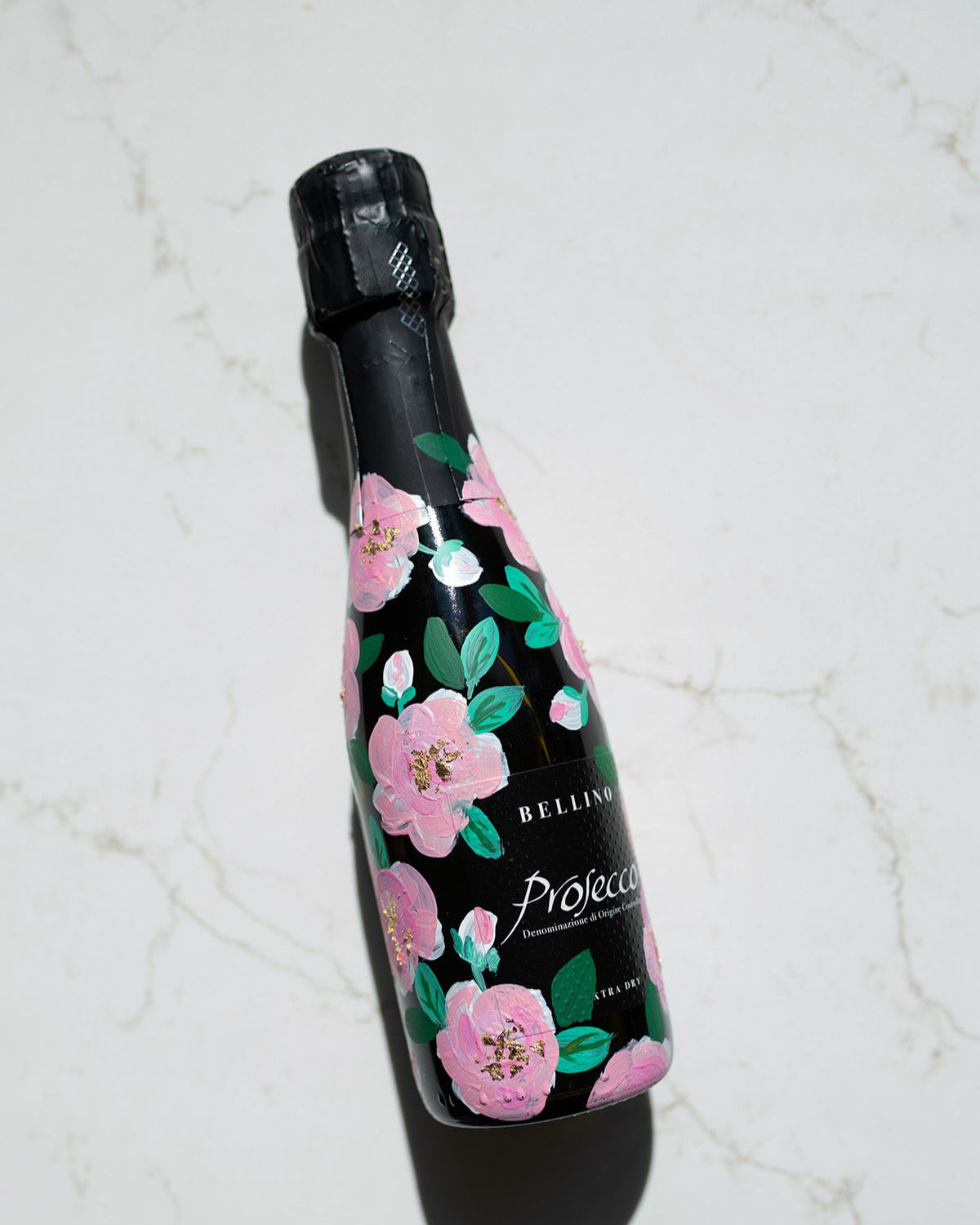 Hand painted pink roses with gold leaf accents in the centres. Painted onto mini bottles of Prosecco. a perfect bridesmaids proposal gift. Fancy Folk Design