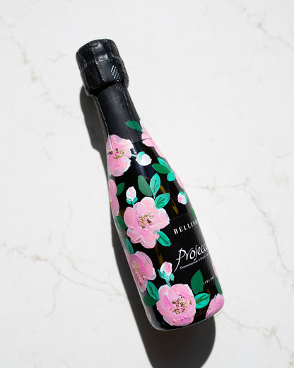 Hand painted pink roses with gold leaf accents in the centres. Painted onto mini bottles of Prosecco. a perfect bridesmaids proposal gift. Fancy Folk Design