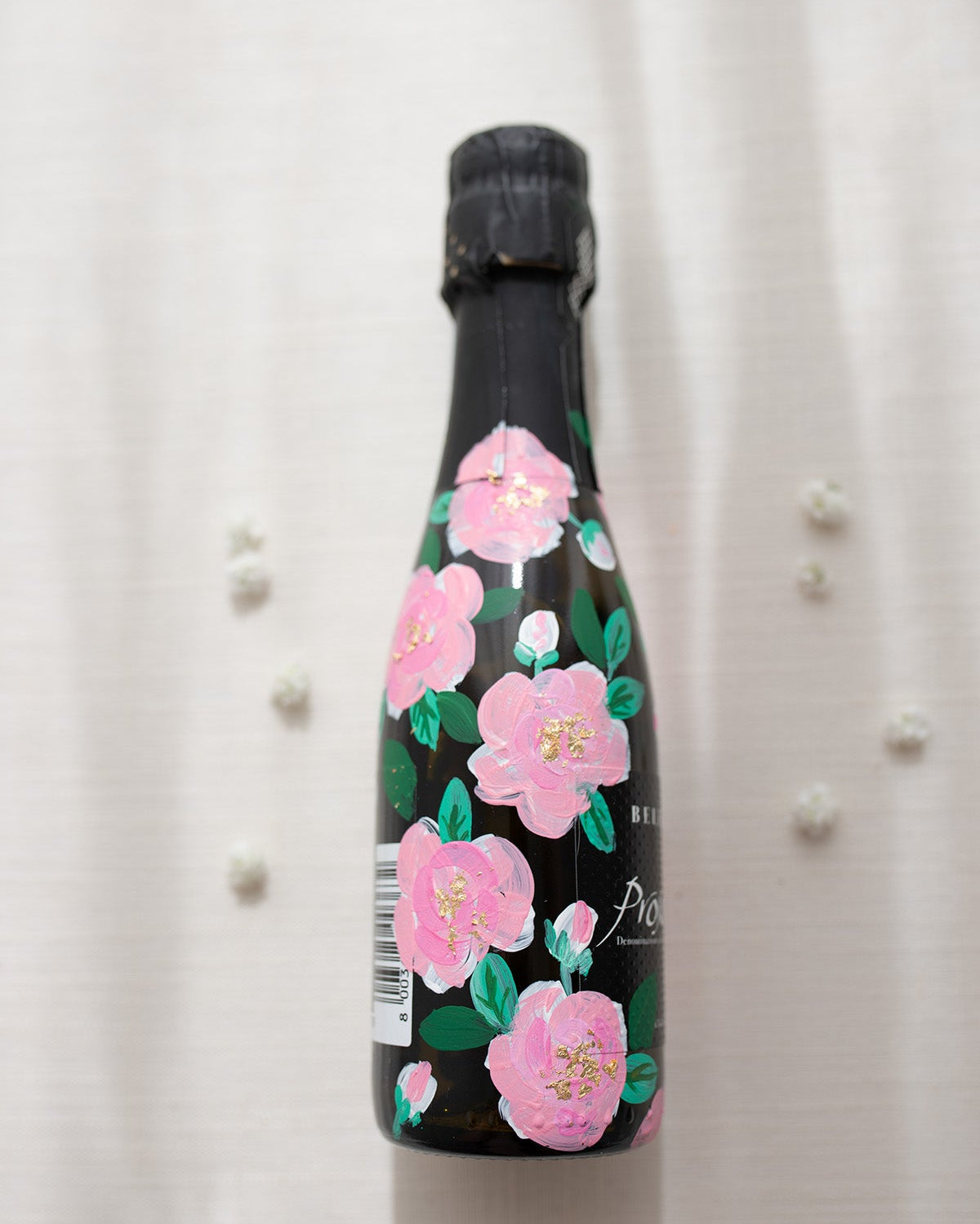 Hand painted pink roses with gold leaf accents in the centres. Painted onto mini bottles of Prosecco. a perfect bridesmaids proposal gift. Fancy Folk Design