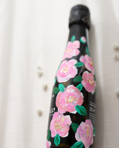 Hand painted pink roses with gold leaf accents in the centres. Painted onto mini bottles of Prosecco. a perfect bridesmaids proposal gift. Fancy Folk Design