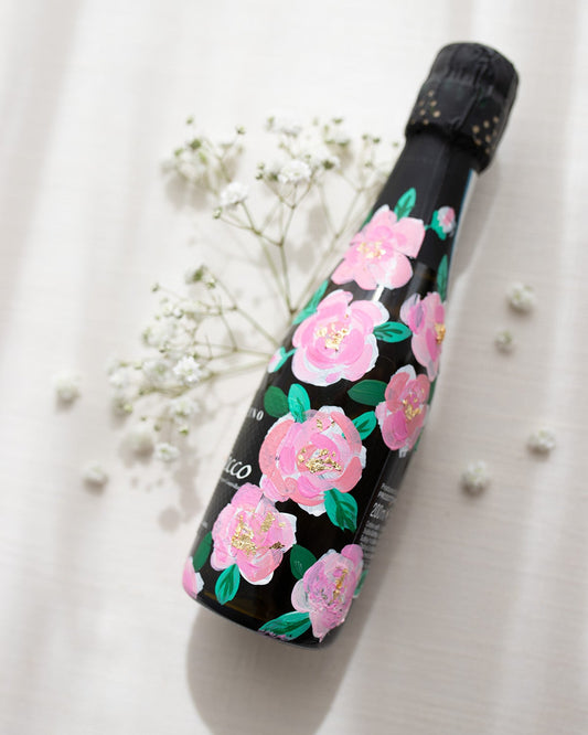 Hand painted pink roses with gold leaf accents in the centres. Painted onto mini bottles of Prosecco. a perfect bridesmaids proposal gift. Fancy Folk Design