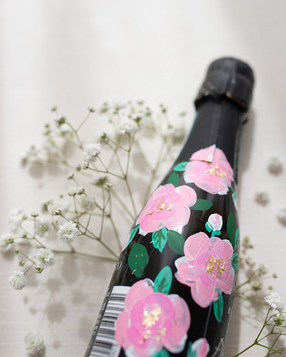 Hand painted pink roses with gold leaf accents in the centres. Painted onto mini bottles of Prosecco. a perfect bridesmaids proposal gift. Fancy Folk Design