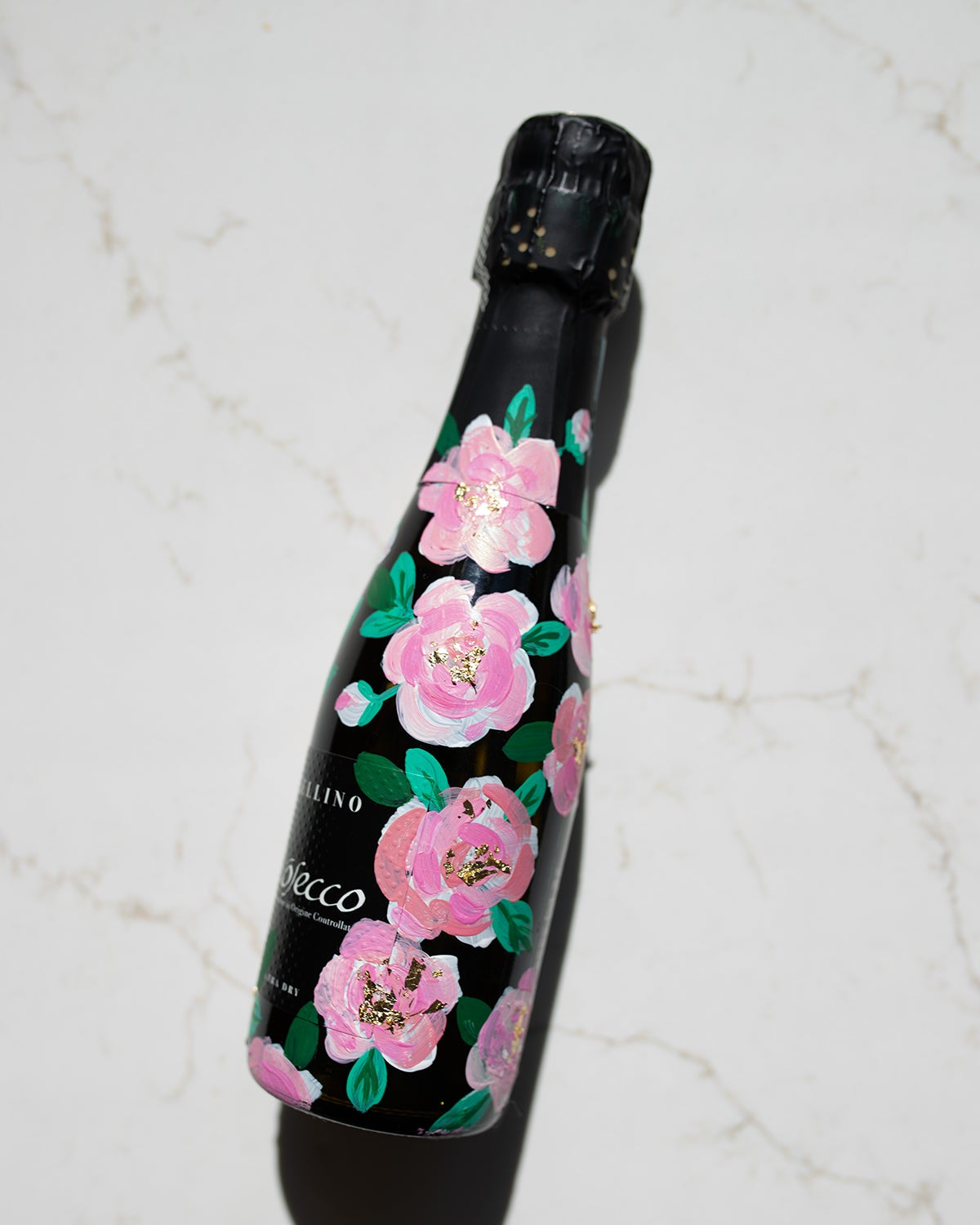 Hand painted pink roses with gold leaf accents in the centres. Painted onto mini bottles of Prosecco. a perfect bridesmaids proposal gift. Fancy Folk Design
