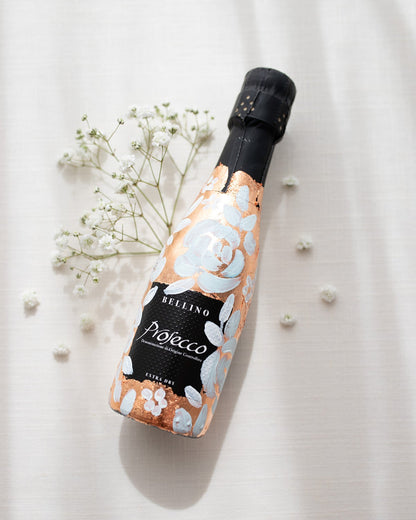 Mini bottles of Prosecco hand painted with a white roses design on a metallic copper leaf base. The perfect luxury bridesmaid proposal gift. Paired with a pink roses panted design available in a separate listing. Fancy Folk Design