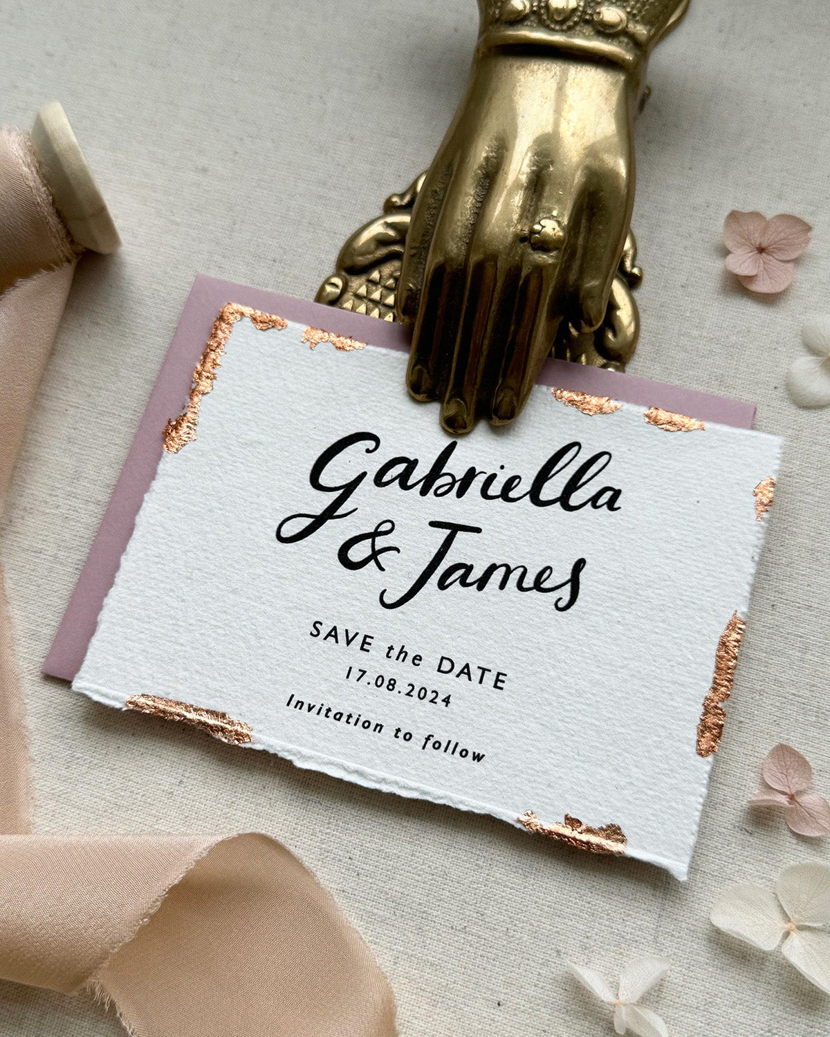 Wedding Save The Date. Beautiful calligraphy names read Gabriella & James with  wedding date below. Printed onto tactile Indian handmade cotton paper. The cards have hand torn edges for a romantic feel with copper leaf accents which sparkle.  Paired with a dusty pink coloured envelope. Fancy Folk