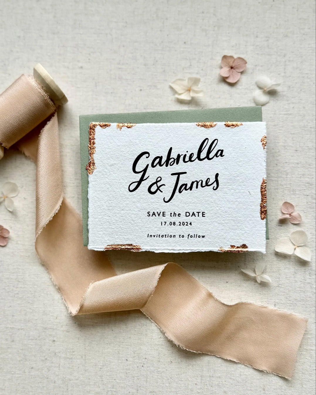 Wedding Save The Date. Beautiful calligraphy names read Gabriella & James with  wedding date below. Printed onto tactile Indian handmade cotton paper. The cards have hand torn edges for a romantic feel with copper leaf accents which sparkle.  Paired with a sage green coloured envelope. Fancy Folk
