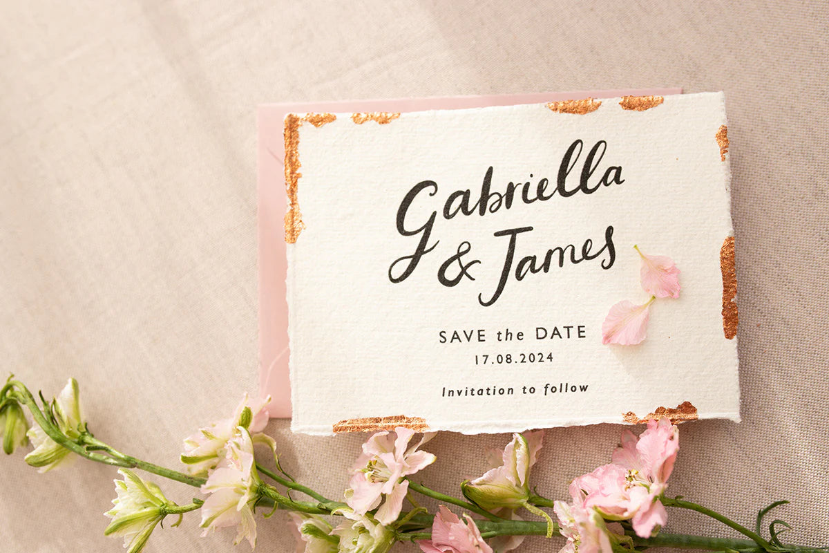 Wedding Save The Date. Beautiful calligraphy names read Gabriella & James with  wedding date below. Printed onto tactile Indian handmade cotton paper. The cards have hand torn edges for a romantic feel with copper leaf accents which sparkle.  Paired with a blush pink coloured envelope. Fancy Folk