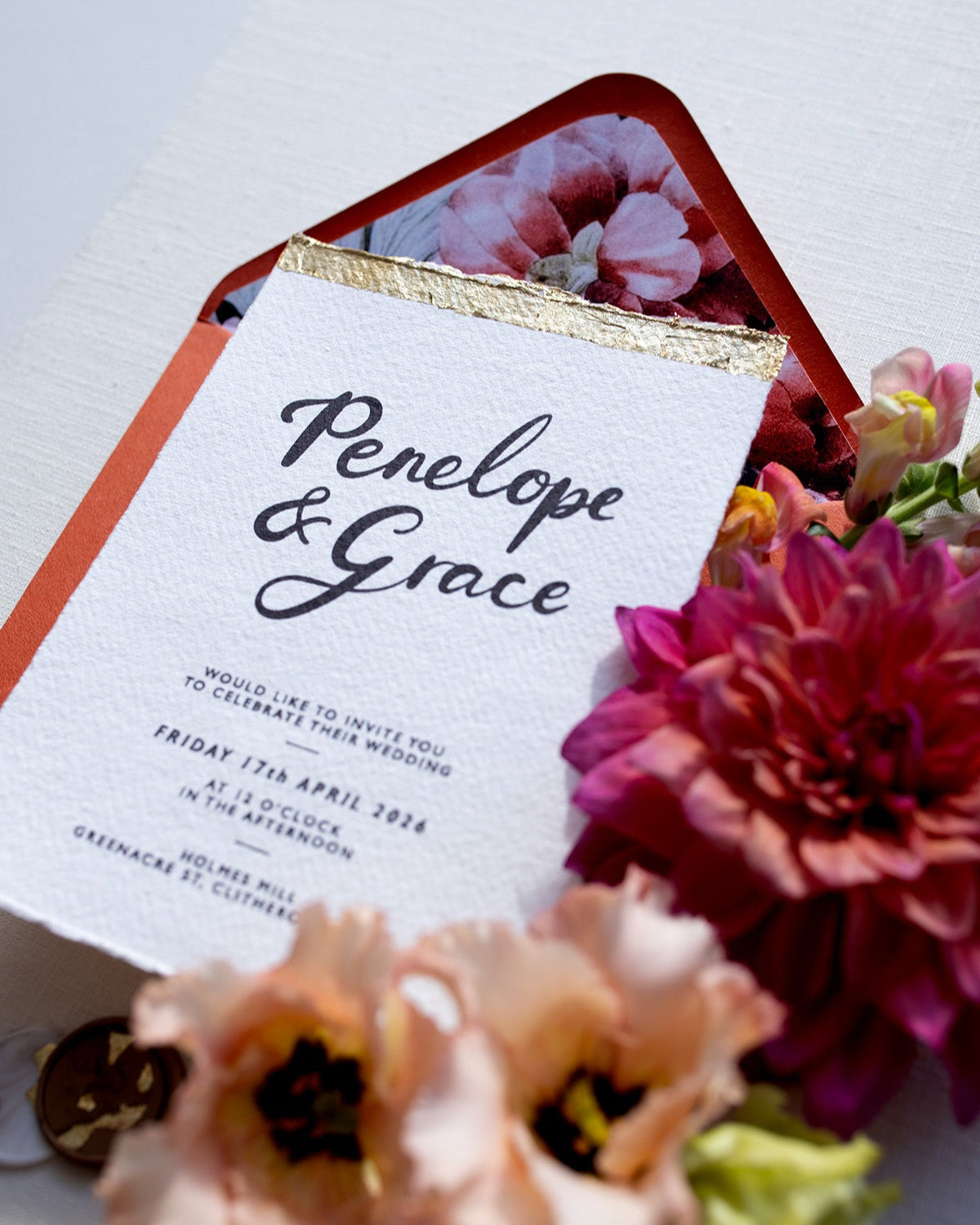 Super shiny gold leaf finish on our Modern Calligraphy Wedding Invitations. Styled with terracotta envelopes and coral, peach and rust coloured florals. Fancy Folk