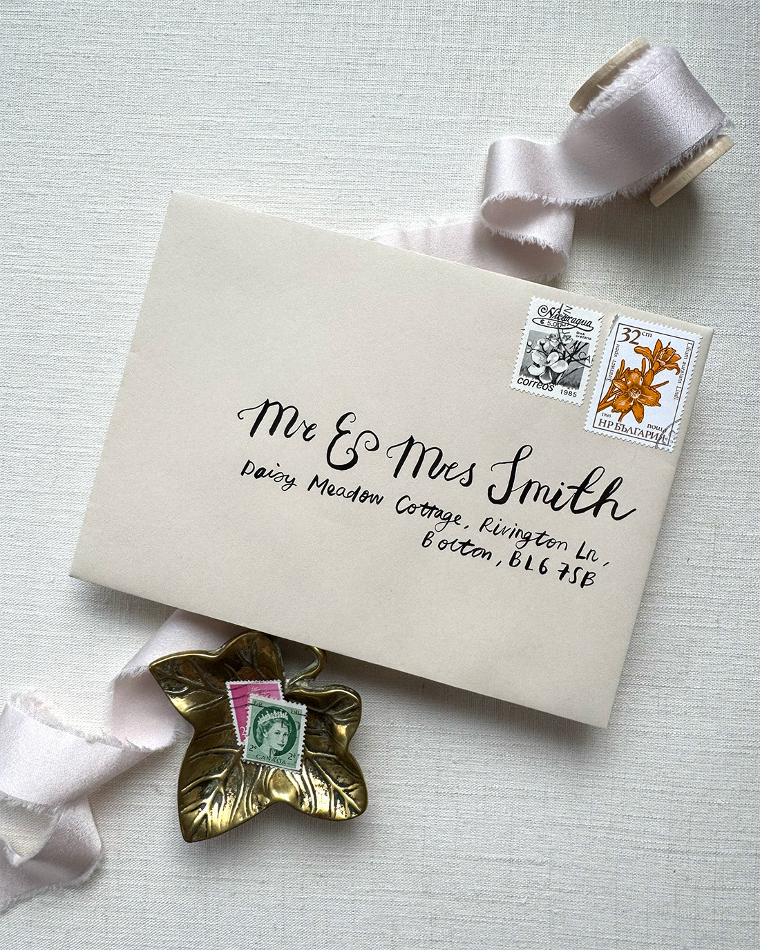 Wedding envelope calligraphy names and address in a black ink. Written on a almond envelope. Fancy Folk