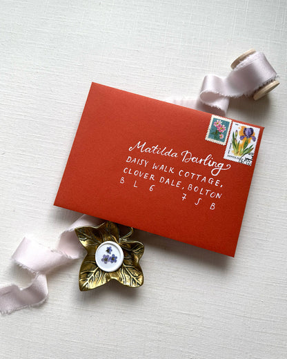 Wedding envelope calligraphy names and address in a white ink. Written on a   terracotta envelope. Fancy Folk