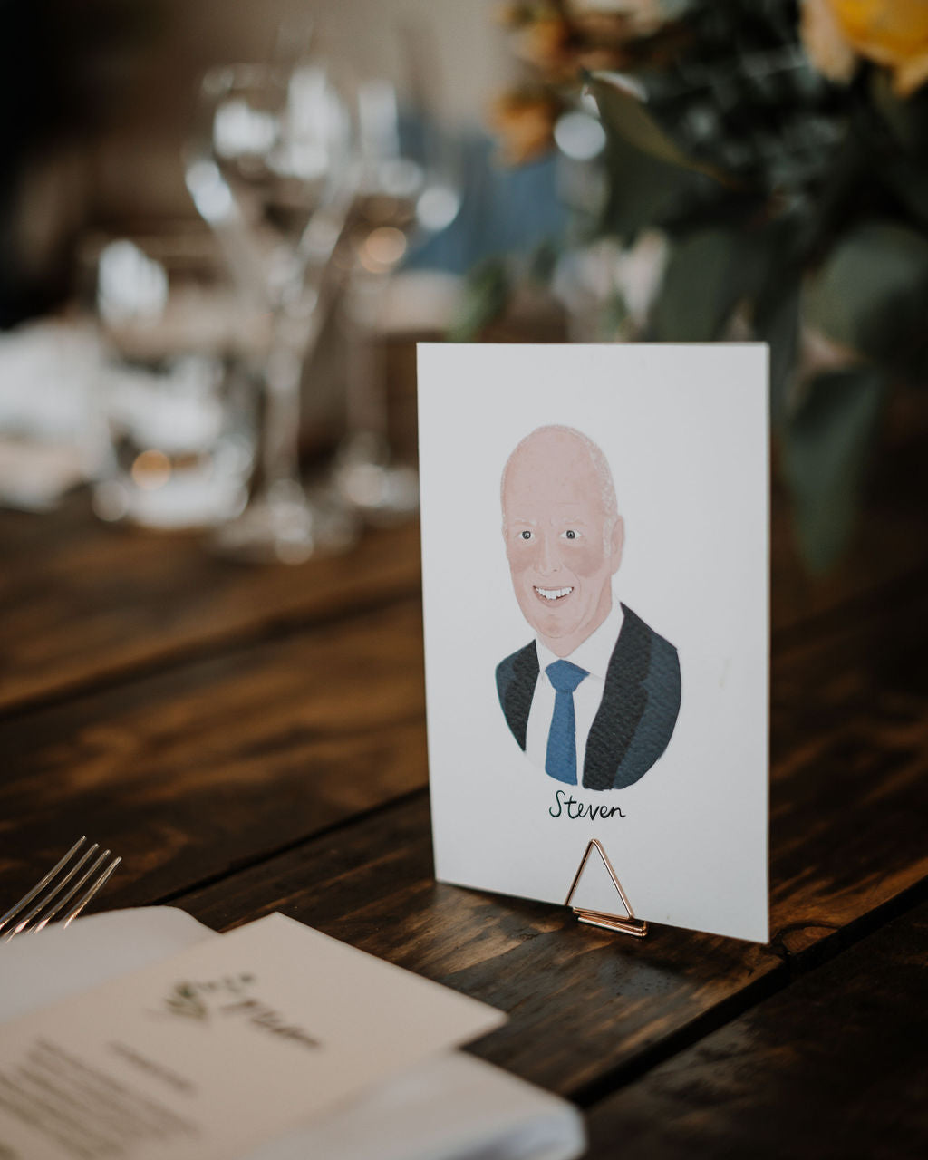 Illustrated wedding portrait of your guests used as a table place cards. Surrounded by florals. Fancy Folk.
