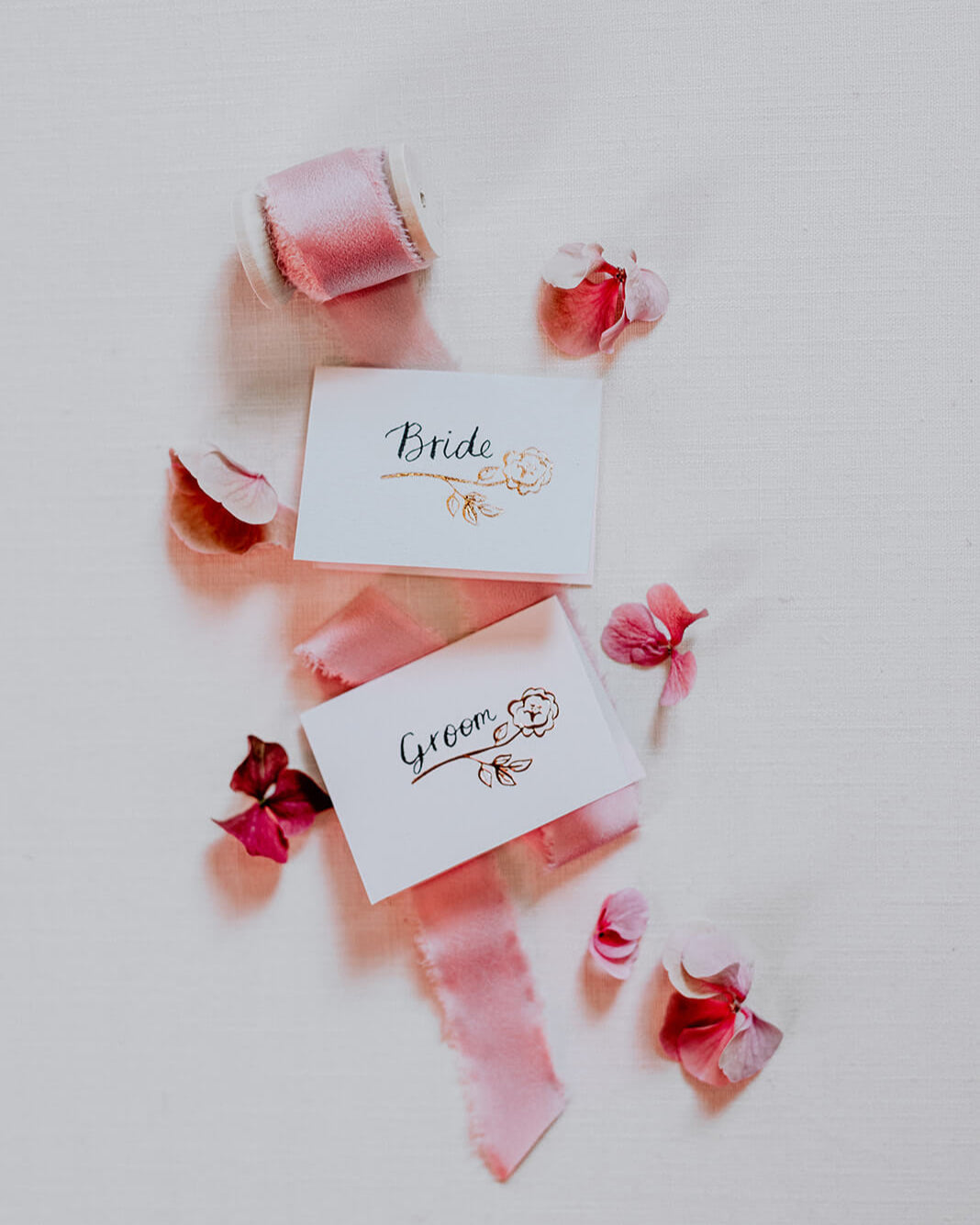 Foiled rose design place card for wedding table with hand calligraphy bride and  groom text. Rose Gold hot foil on textured card.  fancy folk wedding stationery