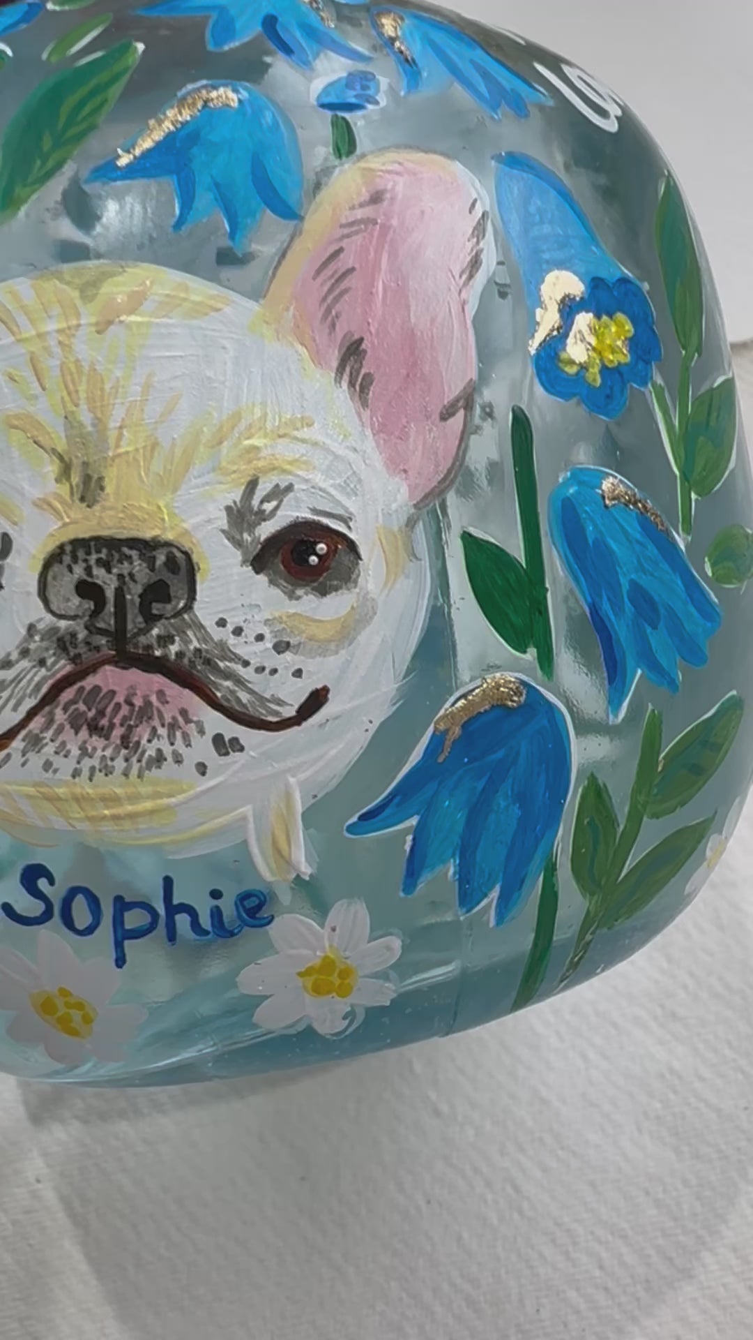 Hand painted pet portrait of a cute french bulldog on a celebration bottle of   alcohol. A pale blue bottle is decorated with beautiful blue florals and calligraphy pets name. Finished with accents of gold leaf. Perfect personalised gift. Fancy Folk