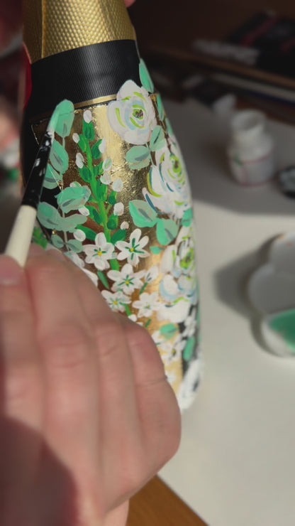 Hand painted Champagne bottle. A video of flowers and eucalyptus being painted onto a gold leaf base. Fancy Folk