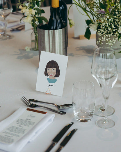 Illustrated wedding portrait of your guests used as a table place card. Surrounded by florals. Fancy Folk.