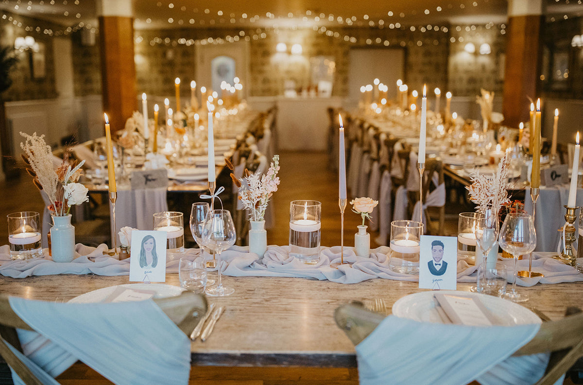 Illustrated wedding portrait of the bride and groom used as a table place card. Surrounded by florals. Fancy Folk.