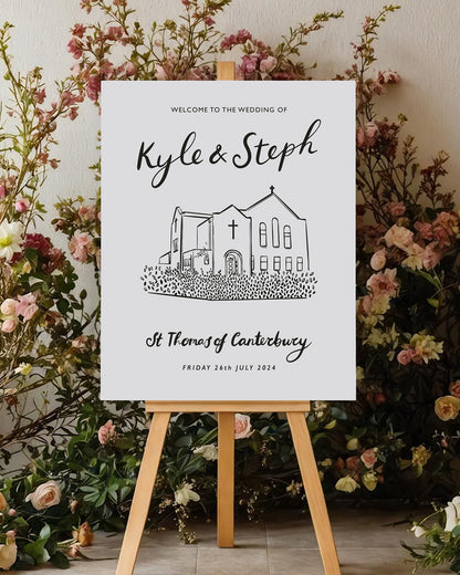 wedding venue illustrated of a church in a line drawing style printed on a large welcome board. Placed on an easel with beautiful floral display behind it.. Fancy Folk